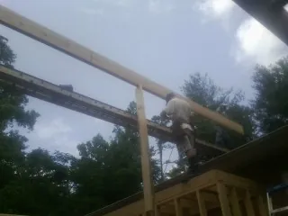 Carpenter setting a ridge beam over a new addition frame — Ice Dam Removal by Roofing Brothers in Steptoe