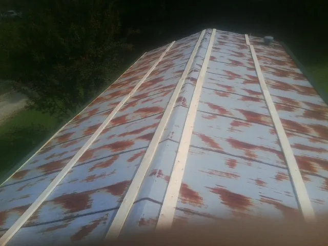 Rusted metal roof panels with new wood purlins before replacement — Storm Damage Roof Repair in Steptoe by Roofing Brothers