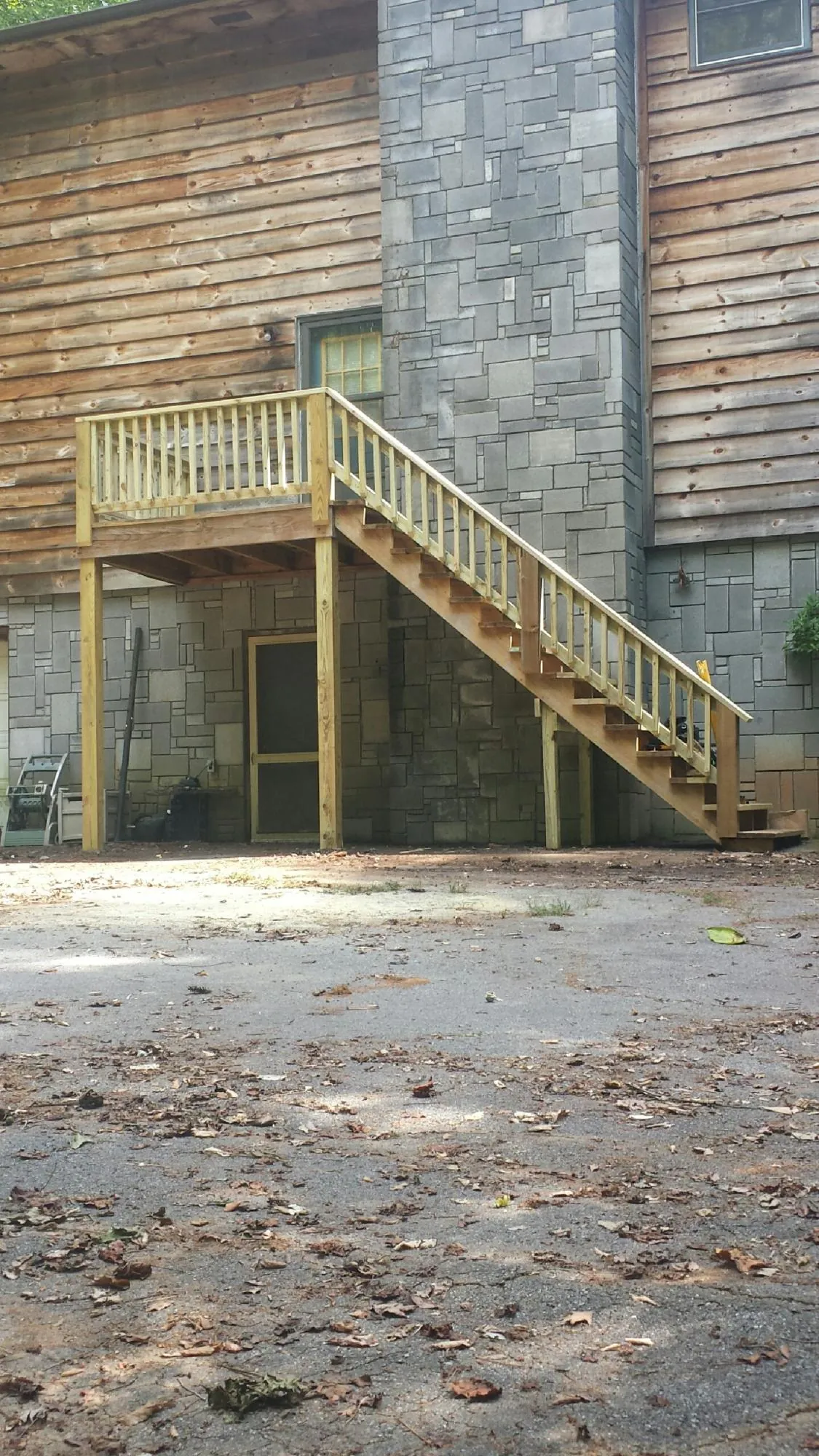 New pressure treated deck and stair landing on a log home in Steptoe