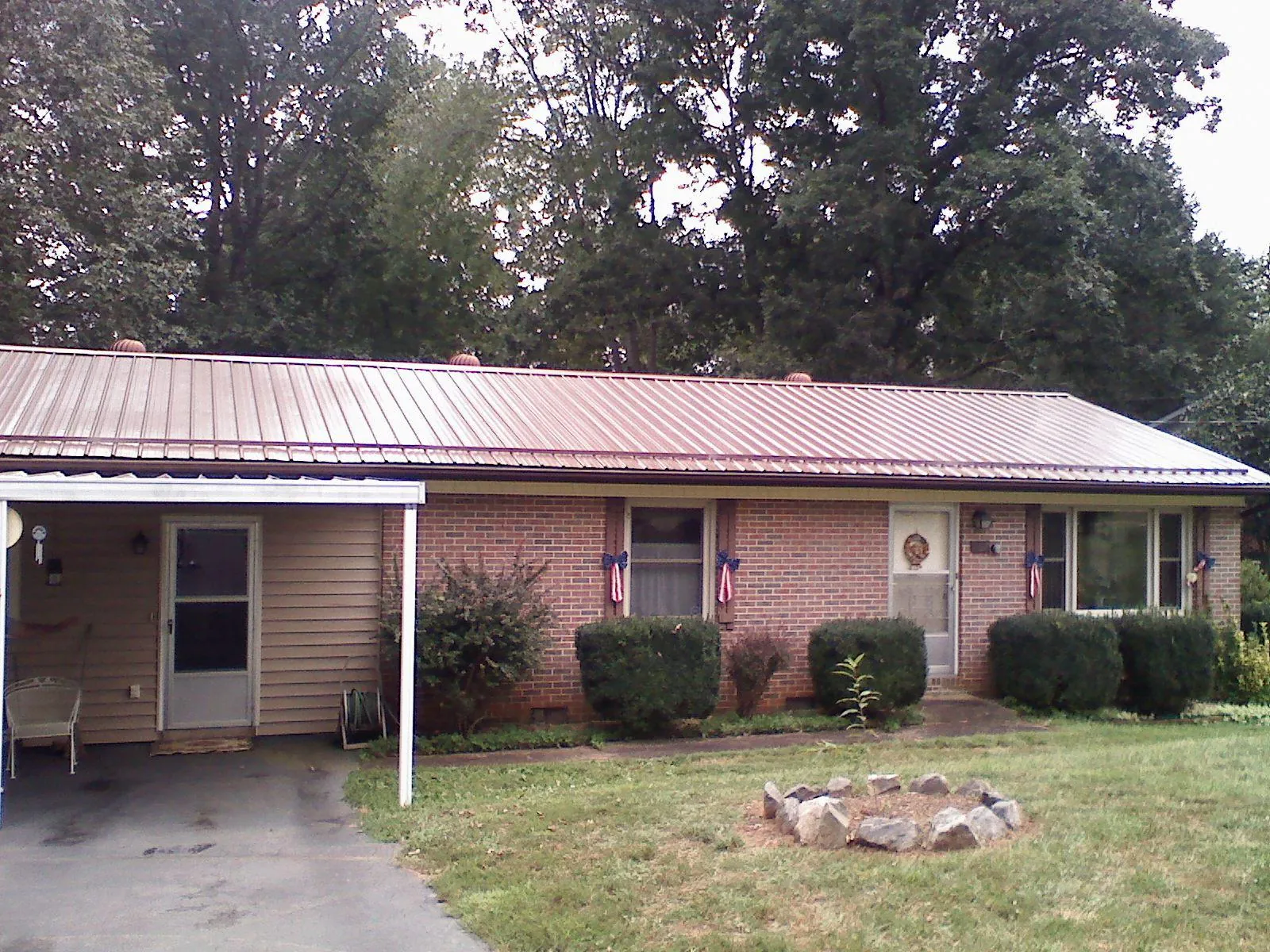 Bronze metal roof and carport on a brick ranch home — Roof Repair work by our crew in Steptoe